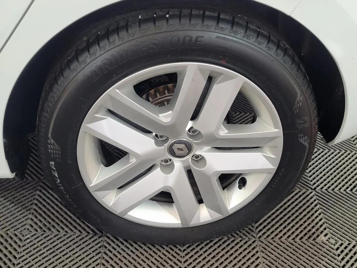 Gros plan sur la roue avant droite blanche d'une Renault Clio Business SCe 65 2021 avec jante alliage argentée.