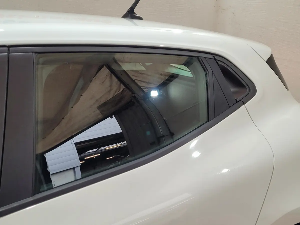 Détail de la vitre arrière côté gauche d'une Renault Clio Business blanche, soulignant la ligne de caisse fluide.
