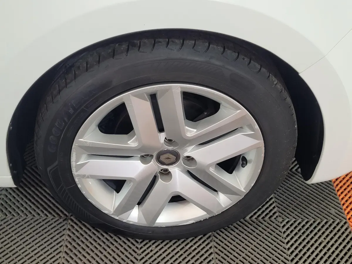 Gros plan sur la roue avant droite blanche d'une Renault Clio Business SCe 65 de 2021 avec jante argentée design moderne.