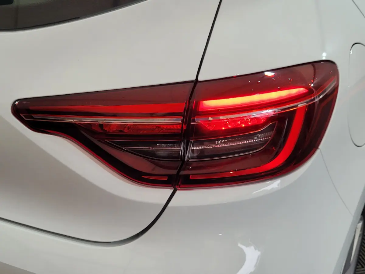 Gros plan sur le feu arrière droit rouge d'une Renault Clio Business blanche de 2021, avec carrosserie lisse.