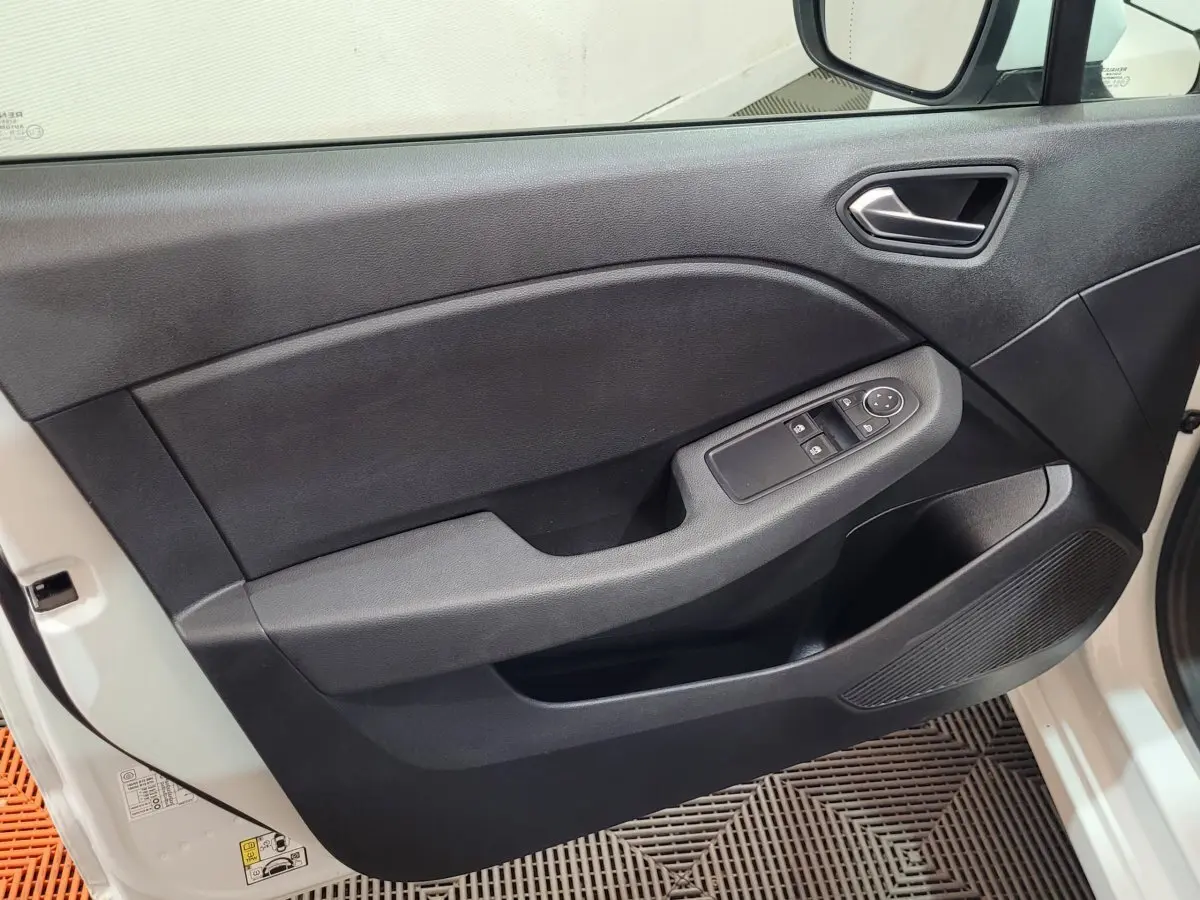 Vue côté gauche de la porte avant noire de la Renault Clio Business blanche avec commandes électriques des vitres.