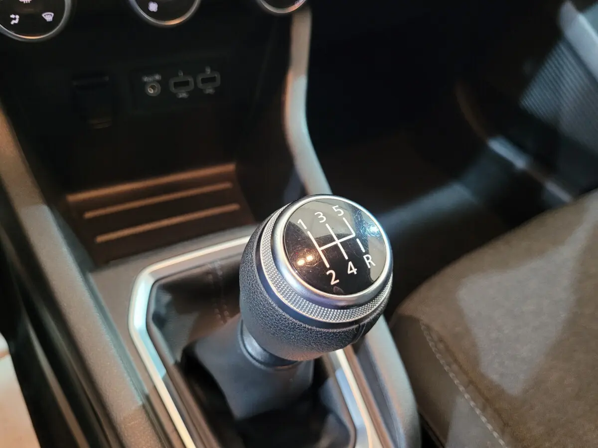 Gros plan sur le levier de vitesses manuel noir de la Renault Clio Business blanche, avec console centrale visible.