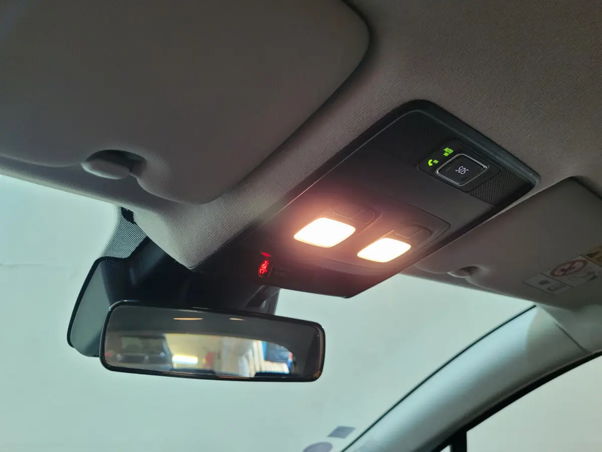 Vue intérieure du plafonnier et rétroviseur central de la Renault Clio Business blanche de 2021 avec éclairage allumé.
