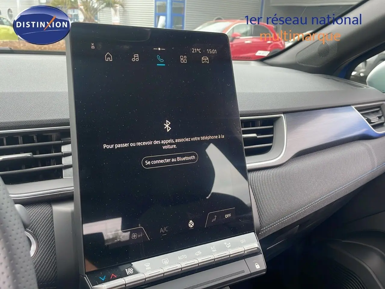 Vue intérieure du tableau de bord du Renault Captur bleu Iron Metal, avec écran tactile central vertical allumé.