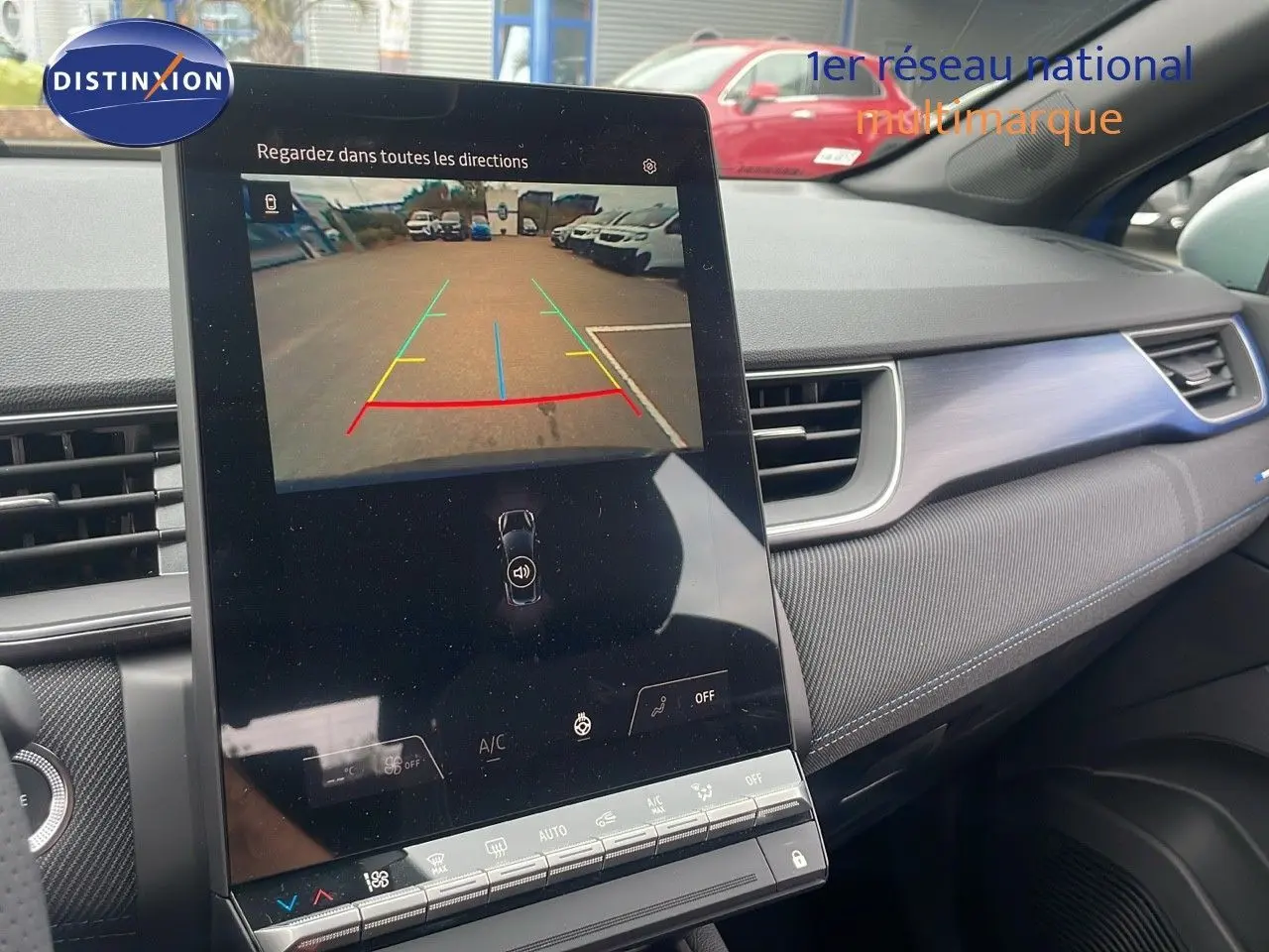 Vue intérieure du tableau de bord du Renault Captur bleu Iron Metal, écran tactile affichant la caméra de recul en marche.
