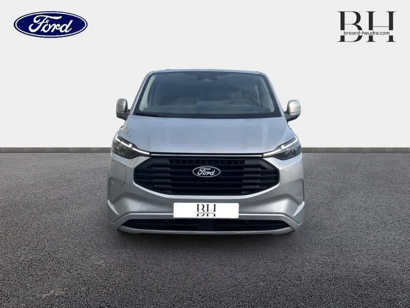 Vue avant du Ford Transit Custom Fourgon gris lunaire métallisé avec calandre noire et phares LED intégrés.