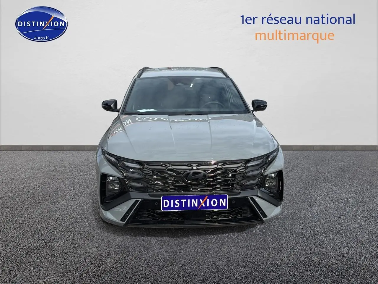 Vue frontale du Hyundai Tucson 2026 gris shadow avec calandre noire glossy et feux LED distinctifs.