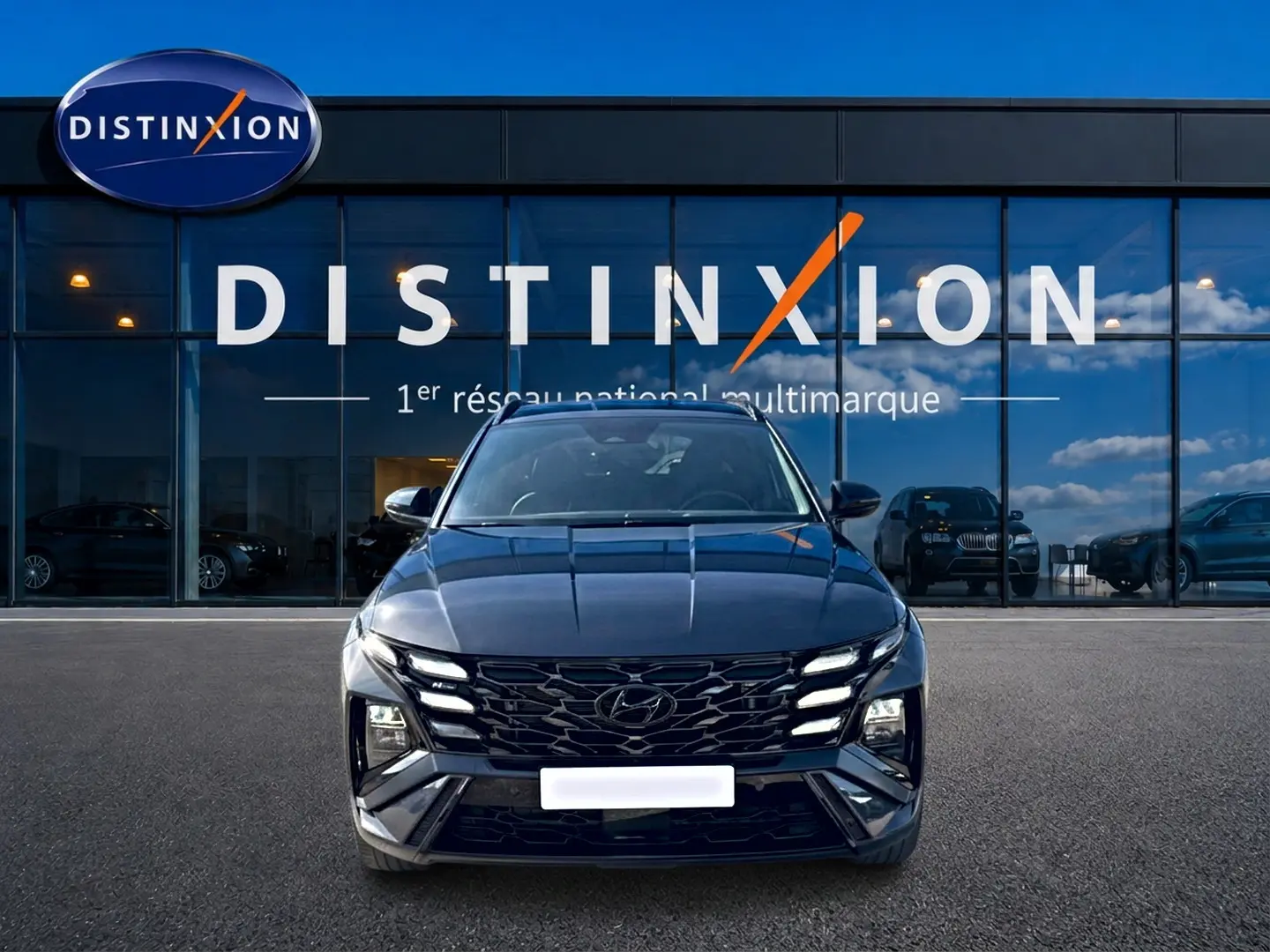 Hyundai Tucson gris ecotronique vu de face, avec calandre glossy black et feux LED distinctifs.
