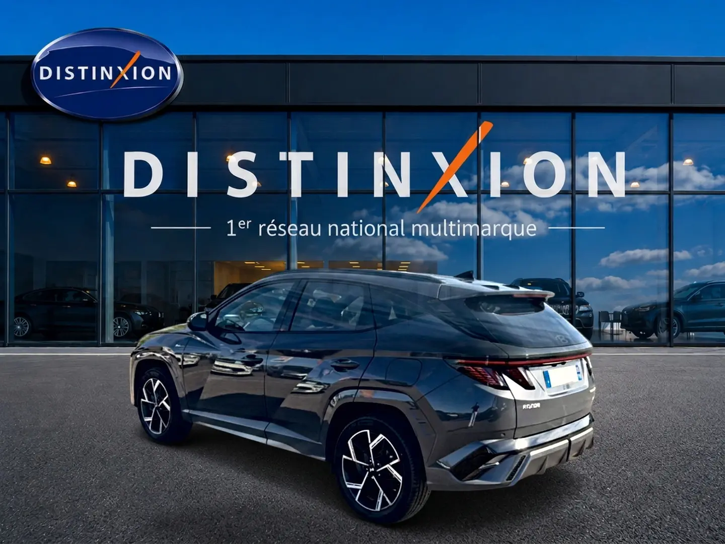 Vue 3/4 arrière droite du Hyundai Tucson 2026 gris ecotronique avec jantes alliage et feux arrière LED distinctifs.