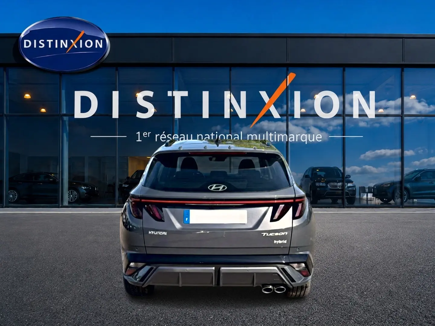 Vue arrière d'un Hyundai Tucson gris ecotronique avec double sortie d'échappement et feux arrière LED en bandeau.