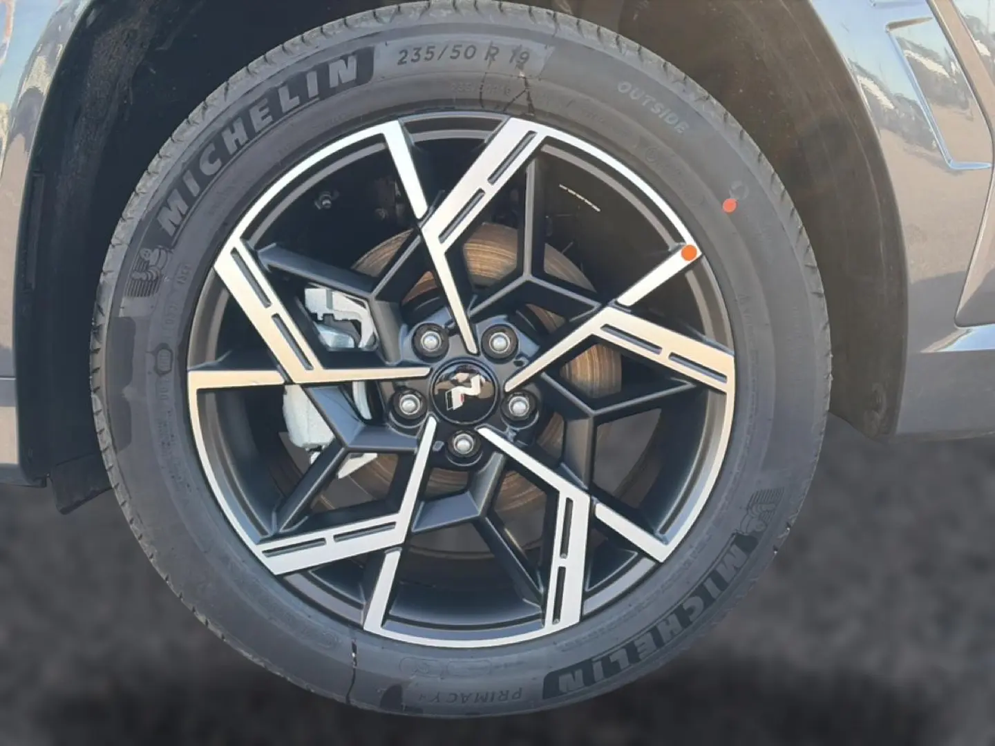 Gros plan sur la jante alliage 19 pouces noire et argentée du Hyundai Tucson gris ecotronique, côté avant droit.