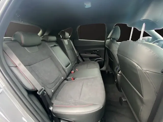 Vue intérieure côté droit des sièges arrière gris foncé avec surpiqûres rouges du Hyundai Tucson 1.6 Hybrid 2026 N Line Creative.