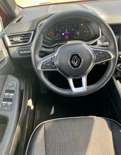 Vue intérieure centrée sur le volant multifonction de la Renault Clio V 1.0 TCE 90CH Intens X-Tronic avec tableau de bord numérique.