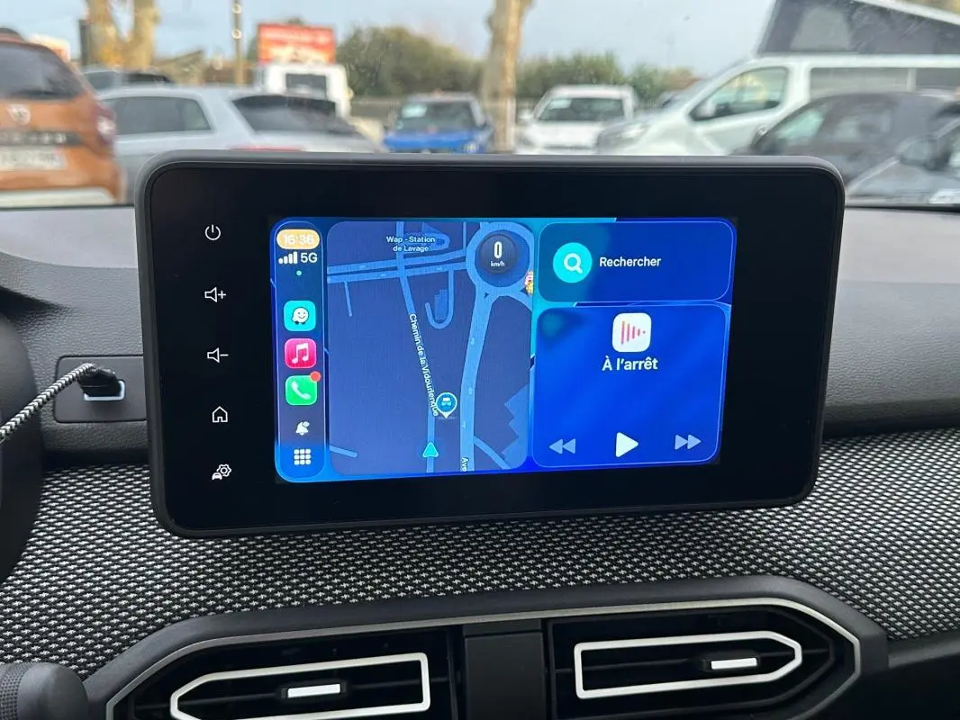 Écran tactile central de la Dacia Sandero blanc 2024 affichant navigation et multimédia, vue intérieure frontale.