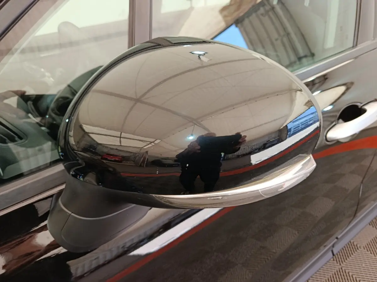 Rétroviseur extérieur droit noir brillant avec clignotant intégré sur FIAT 500X blanc, vue rapprochée.