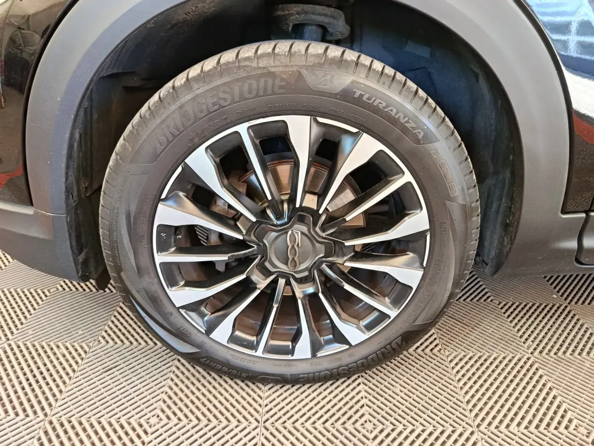 Gros plan sur la roue avant droite avec jante alliage bicolore du FIAT 500X blanc Cross 2020.