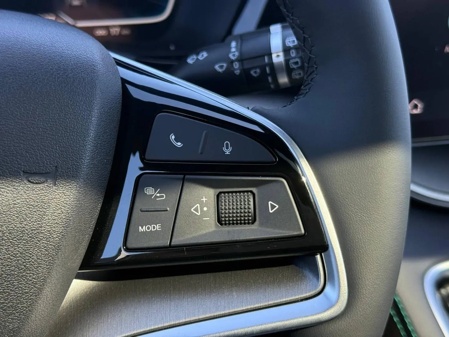 Gros plan sur les commandes multifonctions noires du volant du BYD SEAL U 1.5 DM-i en intérieur lumineux.