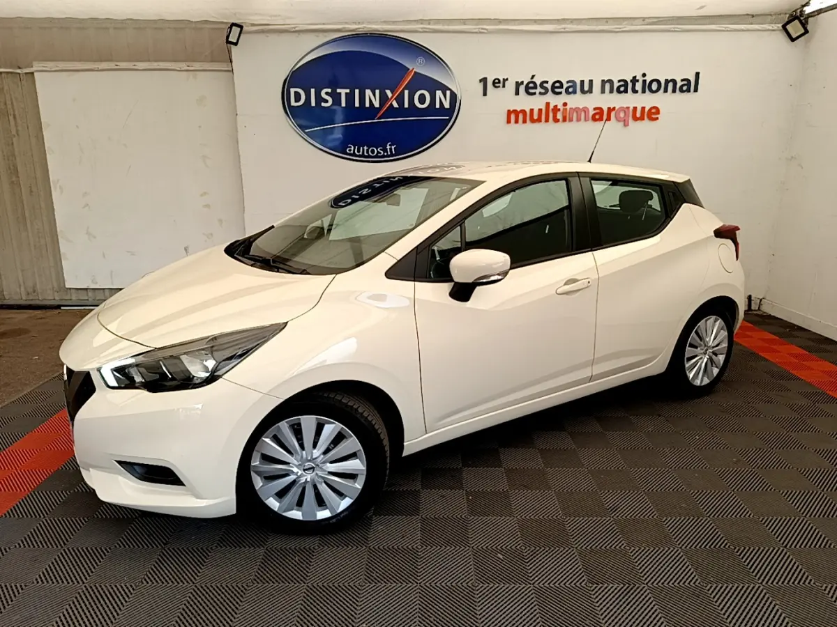 Nissan Micra IG-T 92 Acenta blanche vue de côté droit en intérieur, avec jantes argentées et phares avant visibles.