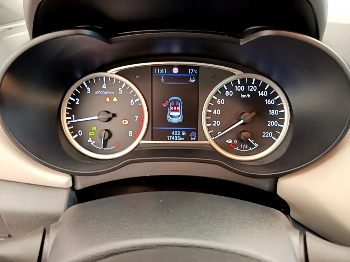 Tableau de bord de Nissan Micra blanc 2022, affichage digital central et compte-tours et vitesse analogiques.