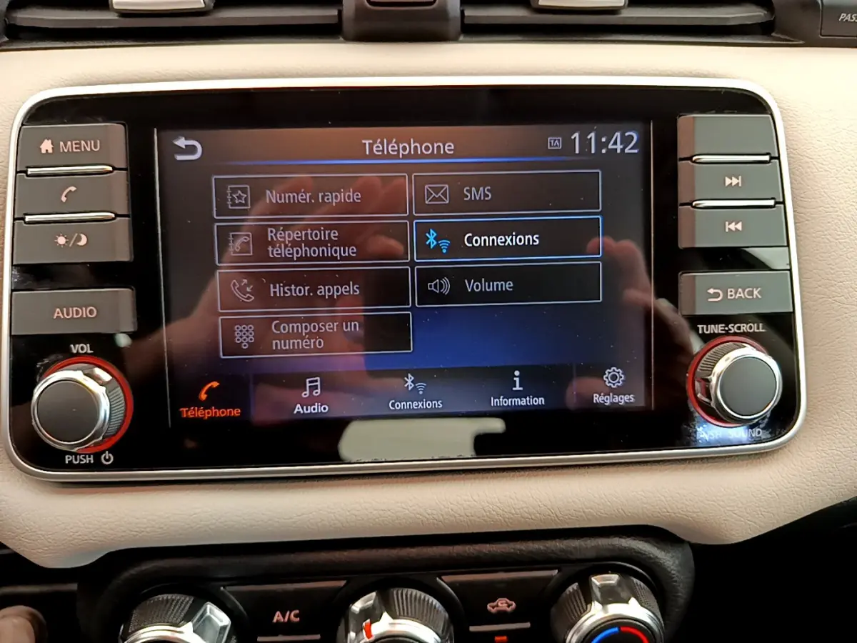 Écran tactile central de la Nissan Micra IG-T 92 Acenta 2022 affichant le menu téléphone sur tableau de bord beige.