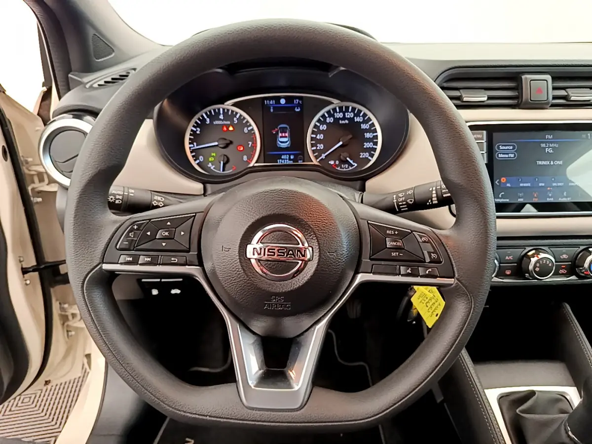 Vue rapprochée du volant noir multifonctions et du tableau de bord digital de la Nissan Micra blanche 2022.