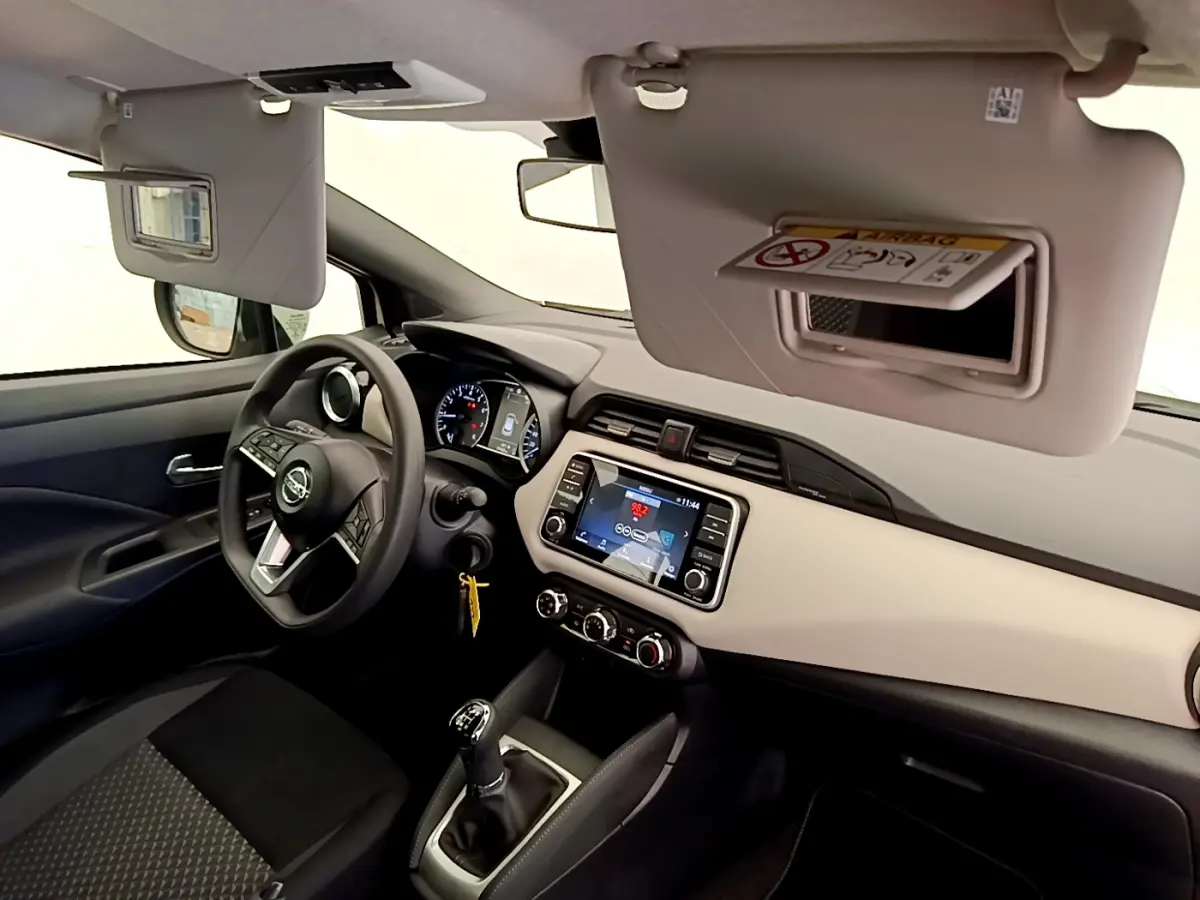 Intérieur de la Nissan Micra IG-T 92 Acenta 2022, vue côté conducteur, tableau de bord beige et écran tactile central.
