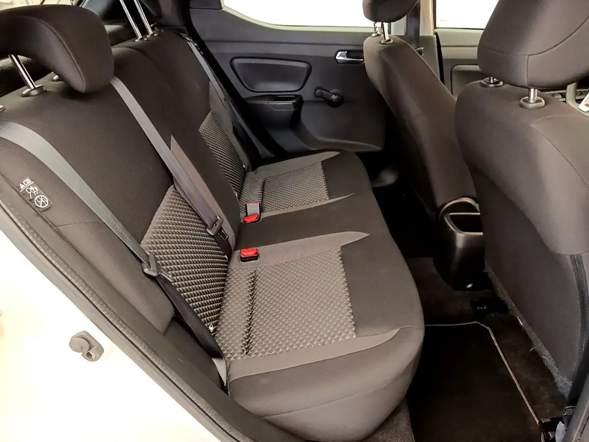 Vue intérieure côté gauche montrant la banquette arrière noire et grise de la Nissan Micra IG-T 92 Acenta blanche.