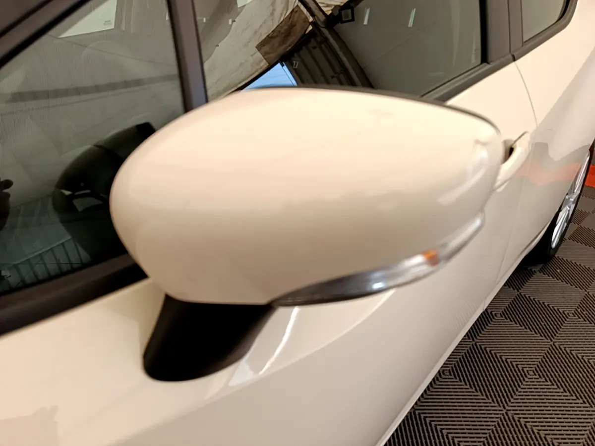 Rétroviseur côté gauche blanc de la Nissan Micra IG-T 92 Acenta 2022 vue en gros plan sur fond intérieur.