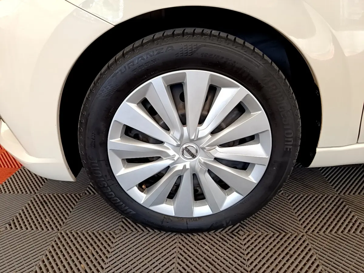 Gros plan sur la roue avant droite d'une Nissan Micra blanche, mettant en valeur la jante et le pneu Bridgestone.