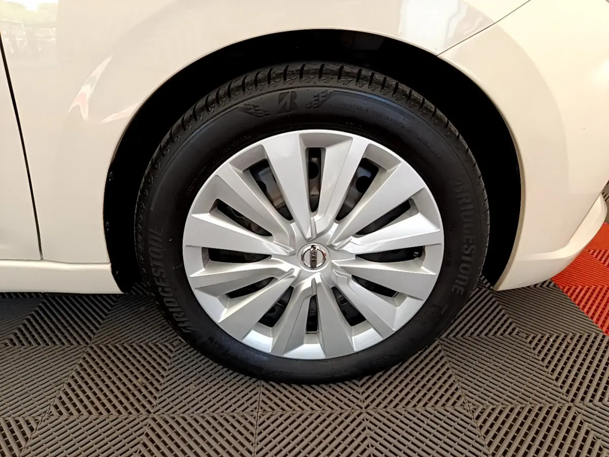 Gros plan sur la roue avant droite d'une Nissan Micra blanche 2022 avec enjoliveur argenté et pneu Bridgestone.