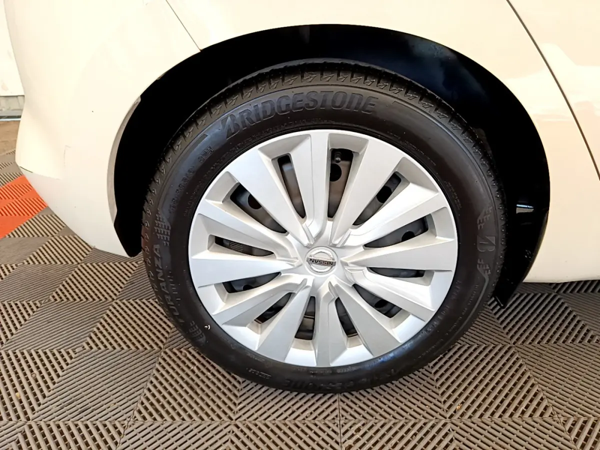 Gros plan sur la roue avant gauche blanche d'une Nissan Micra IG-T 92 Acenta avec jante en alliage argenté.