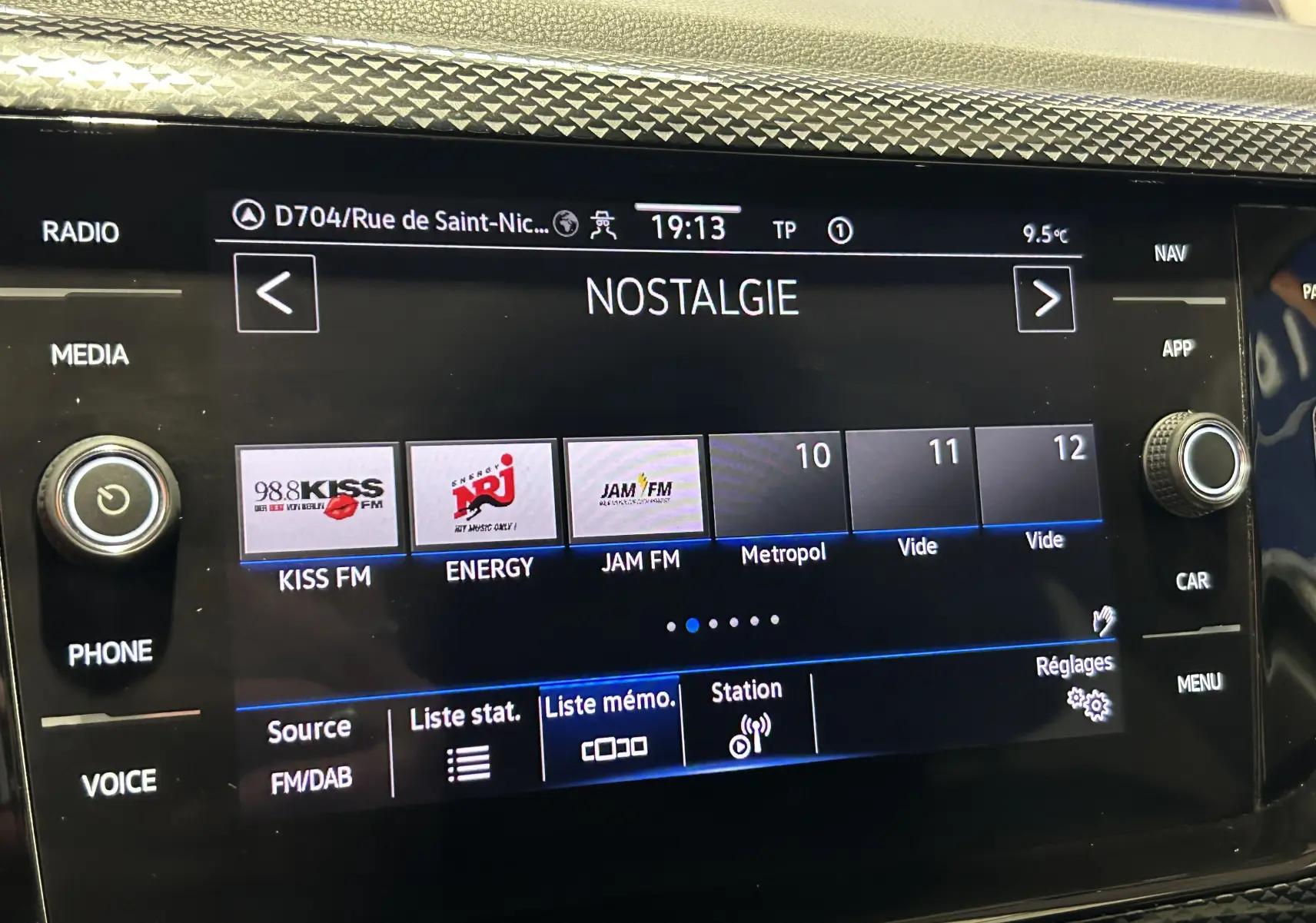Gros plan sur l'écran tactile central du Volkswagen Polo 2022 noir, affichant les stations radio avec interface moderne.