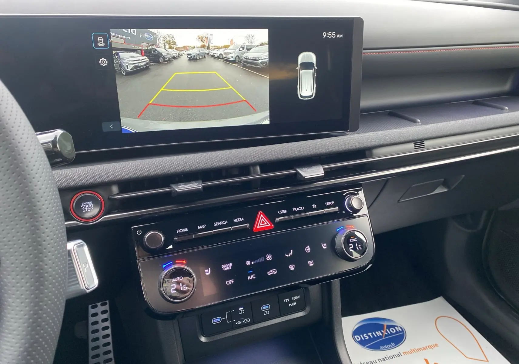 Vue intérieure du tableau de bord du Hyundai Tucson gris, avec écran de caméra de recul et commandes climatisation digitales.