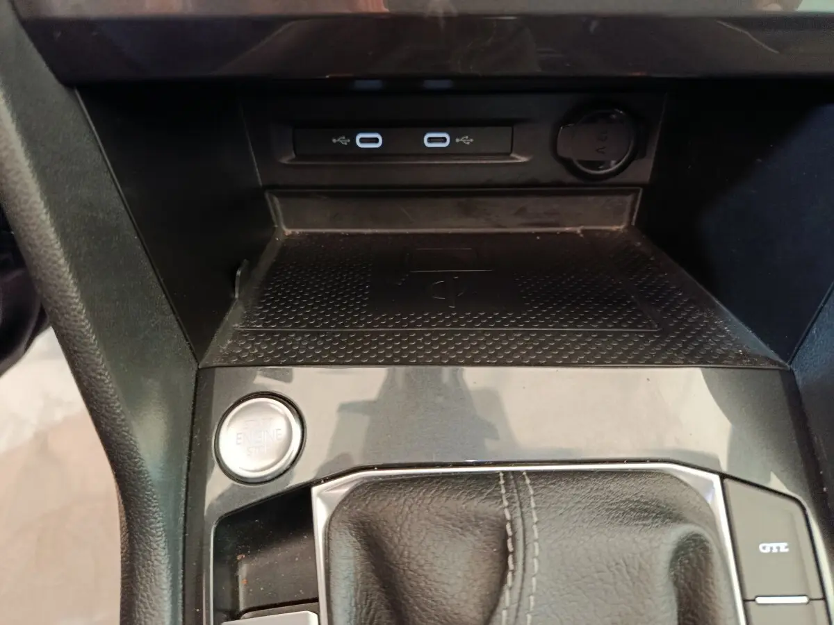 Vue rapprochée de la console centrale noire du Volkswagen Tiguan avec bouton start/stop et ports USB-C.