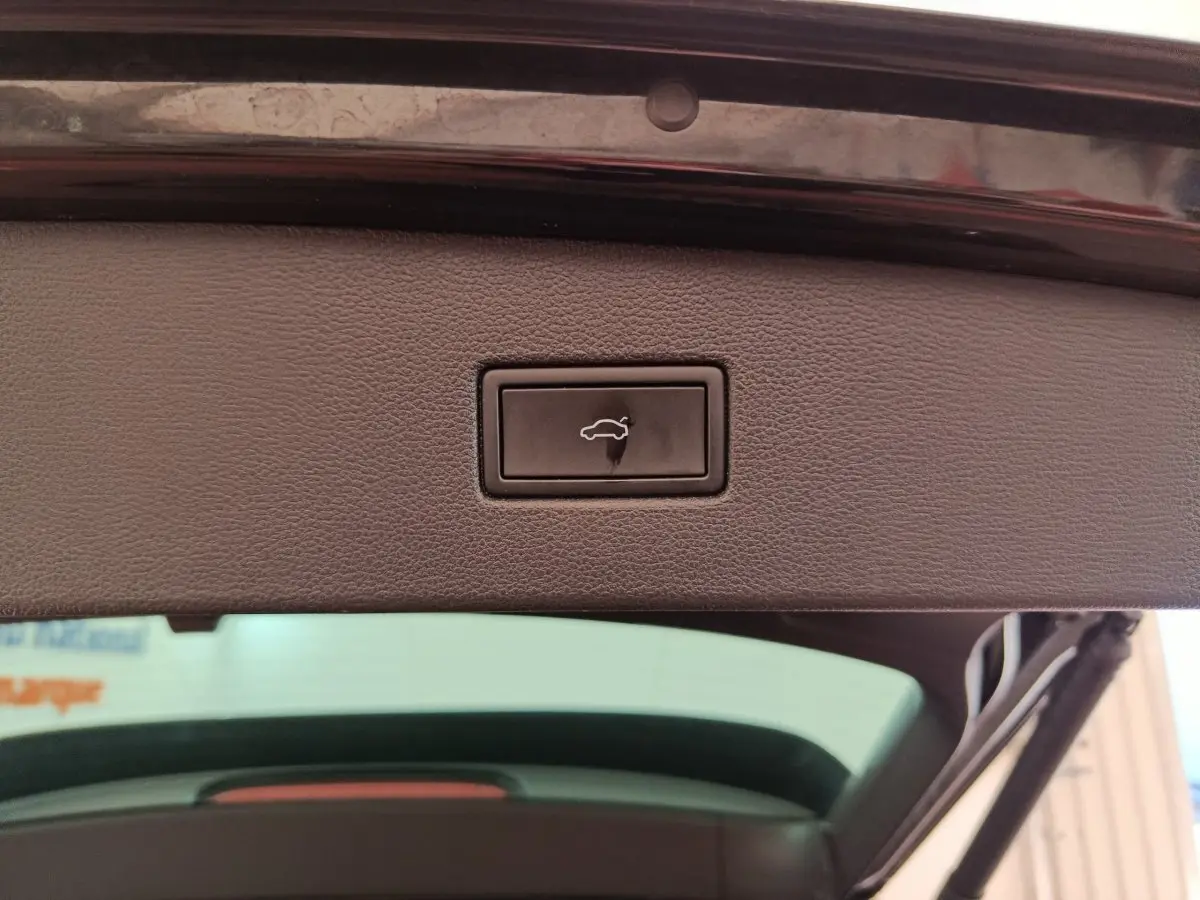 Bouton d'ouverture électrique du coffre sur la partie intérieure du hayon d'un Volkswagen Tiguan noir 2023.