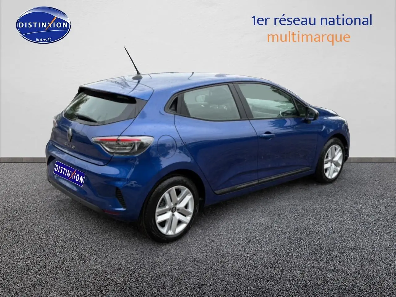 Renault Clio V bleu iron vue 3/4 arrière droit avec becquet et feux arrière LED distinctifs.