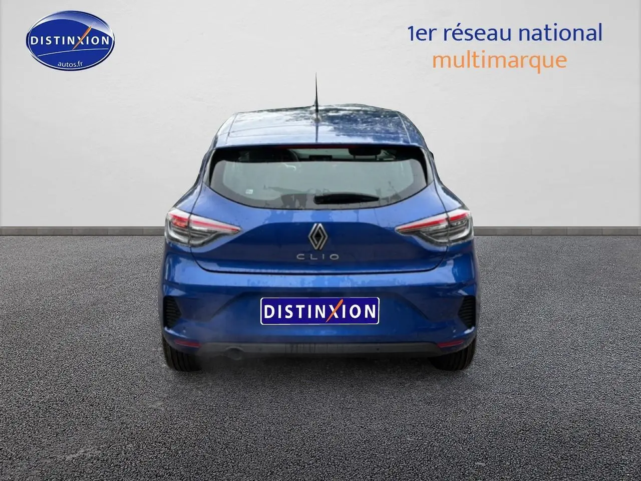 Vue arrière d'une Renault Clio V bleu iron garée sur sol gris, avec feux arrière LED et logo Renault visible.