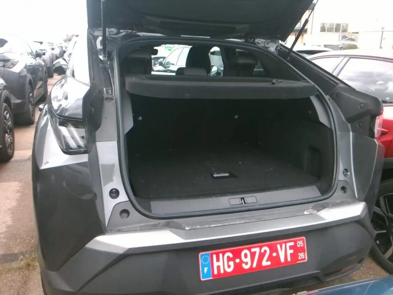 Vue arrière du Peugeot 3008 gris foncé 2025 avec coffre ouvert, soulignant son espace de chargement spacieux.