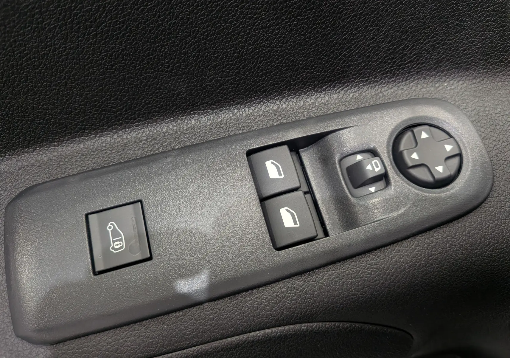 Panneau de commandes des vitres et rétroviseurs côté conducteur du Citroën Berlingo blanc 2025, vue rapprochée.