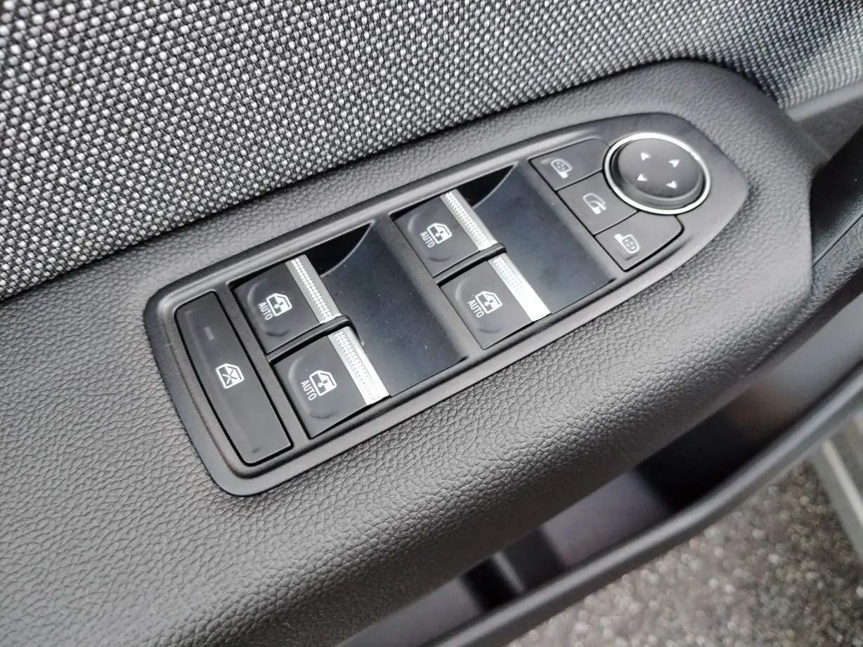 Panneau de commandes des vitres électriques et rétroviseurs sur la porte côté conducteur d'un Renault Captur gris Cassiopée toit noir.