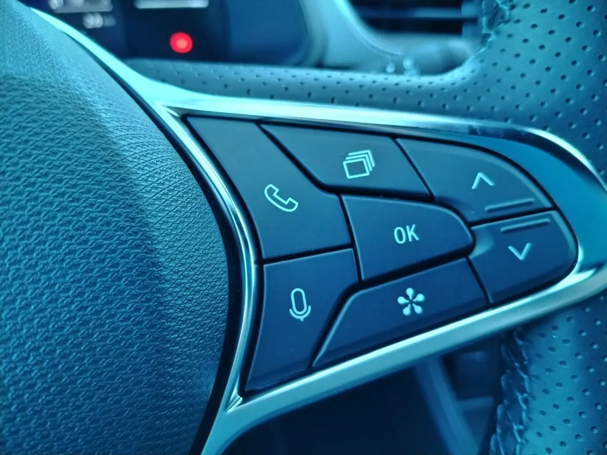 Gros plan sur les boutons de commande au volant côté gauche du Renault Captur gris cassiopée toit noir 2025.