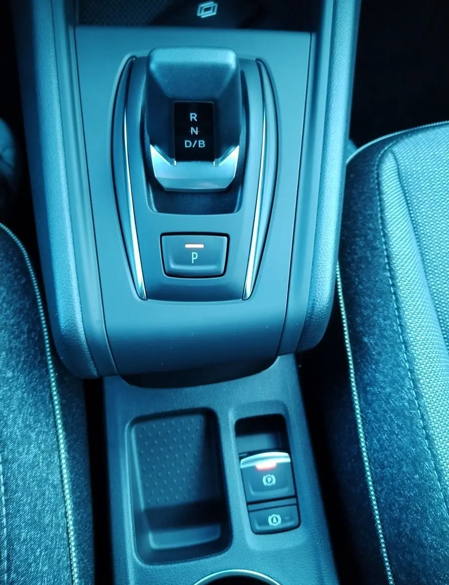 Vue plongeante sur la console centrale du Renault Captur E-Tech gris cassiopée, avec levier de vitesses automatique et frein à main électronique.