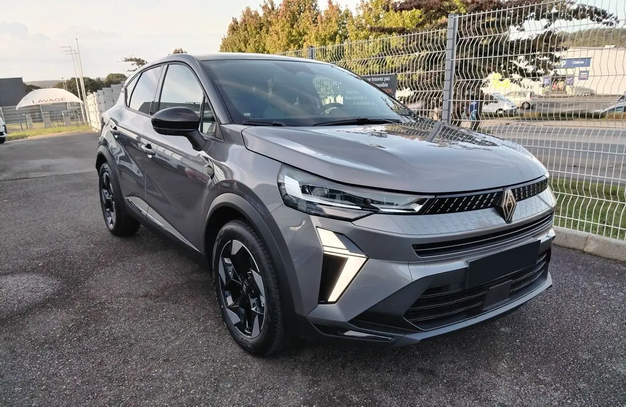 Renault Captur E-Tech gris Cassiopée toit noir en 3/4 avant droit avec feux LED et jantes biton noires.