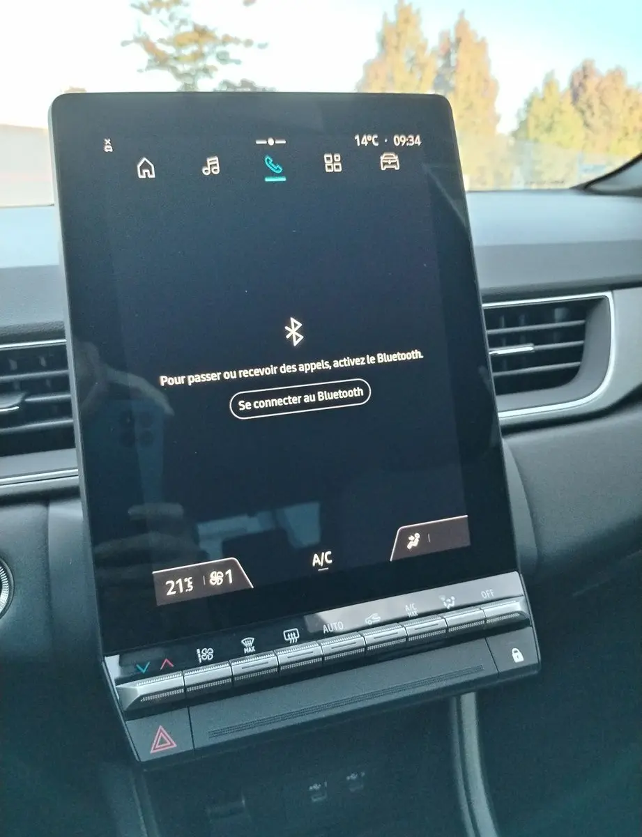 Écran tactile central allumé du tableau de bord du Renault Captur E-Tech gris cassiopée, affichant la connexion Bluetooth.