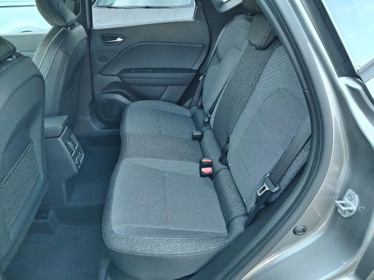 Vue intérieure côté droit des sièges arrière gris tissu du Renault Captur E-Tech Full Hybrid 160ch 2025 avec portières ouvertes.