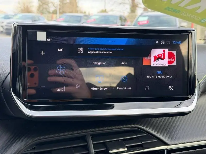 Écran tactile central de la Peugeot 2008 Hybrid 2025 affichant les applications internet et la radio NRJ.