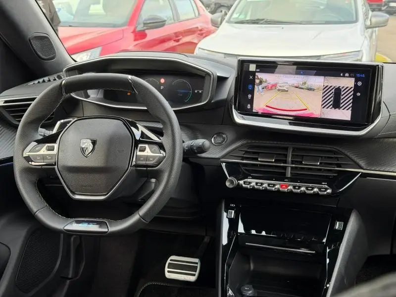 Vue intérieure du tableau de bord et volant cuir multifonction du Peugeot 2008 Hybrid bleu, avec écran tactile affichant la caméra de recul.
