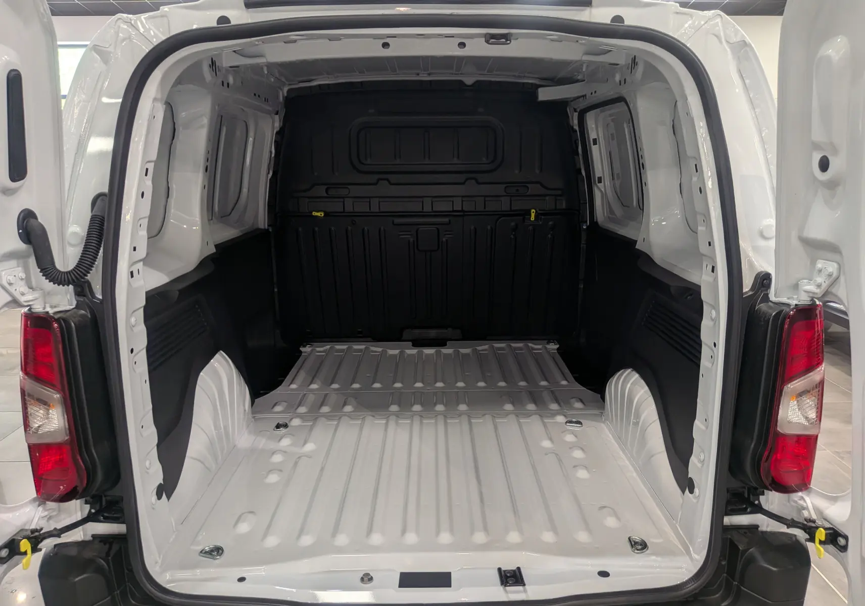 Vue arrière ouverte du Citroën Berlingo Van blanc 2025 montrant l'espace de chargement vide et les feux arrière rouges.