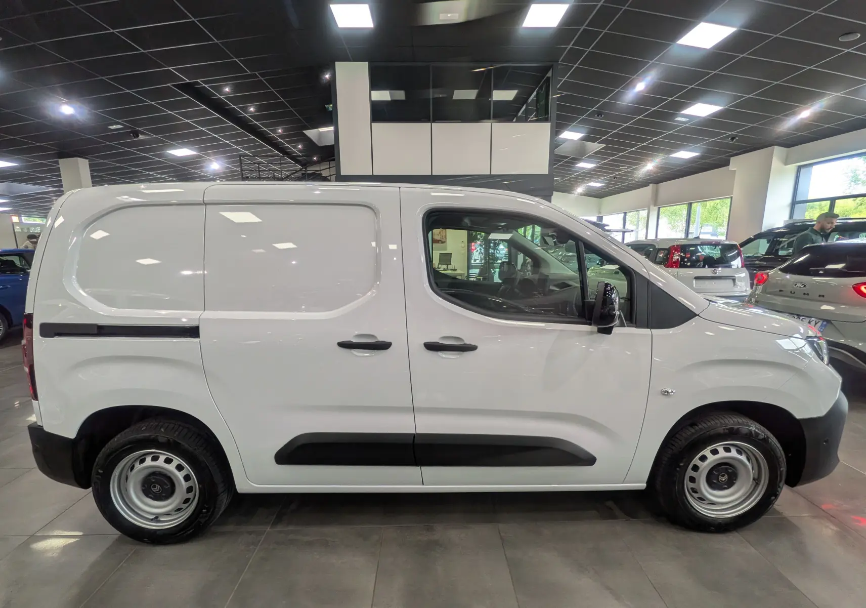 Vue de profil côté gauche d'un Citroën Berlingo blanc 2025 en version VAN Diesel, avec détails noirs contrastants.