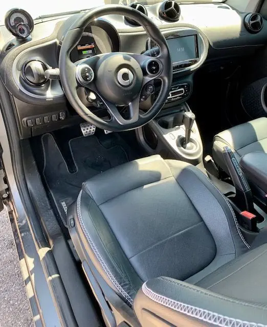 Intérieur côté conducteur du Smart Fortwo électrique gris 2019, volant multifonction et console centrale moderne.